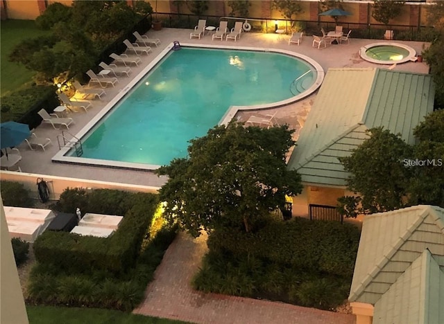 community pool with a hot tub and a patio