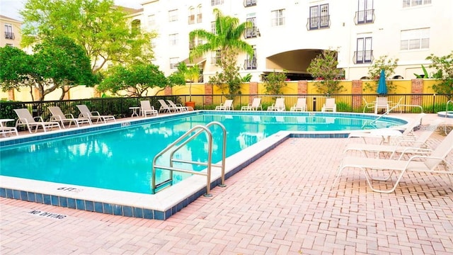 community pool featuring fence and a patio