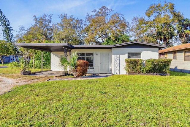 view of front of house with driveway, a front lawn, and an attached carport