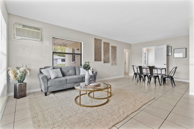 living area with a wall mounted air conditioner, light tile patterned flooring, and baseboards