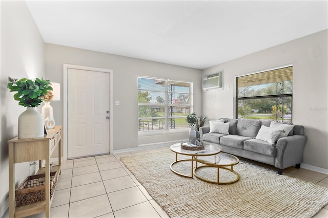 living room with plenty of natural light, an AC wall unit, light tile patterned flooring, and baseboards