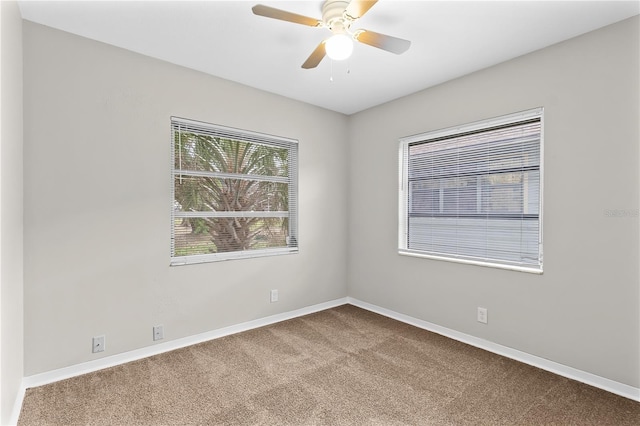 carpeted empty room with ceiling fan and baseboards