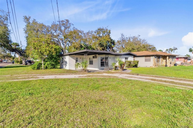 view of front of house with dirt driveway and a front lawn