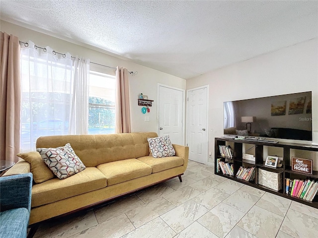 living area with a textured ceiling and marble finish floor