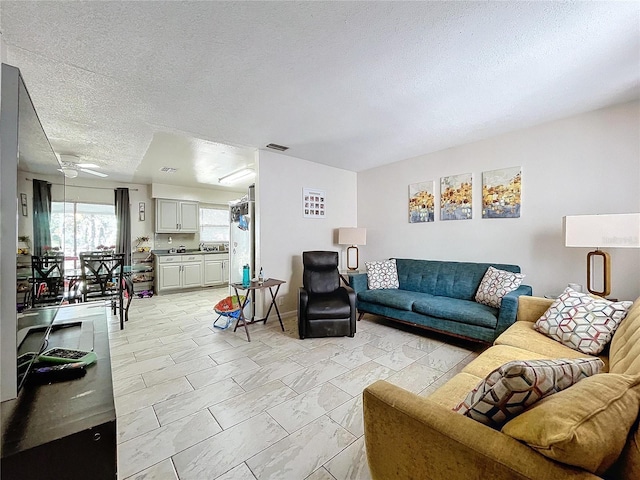 living area with visible vents and a textured ceiling