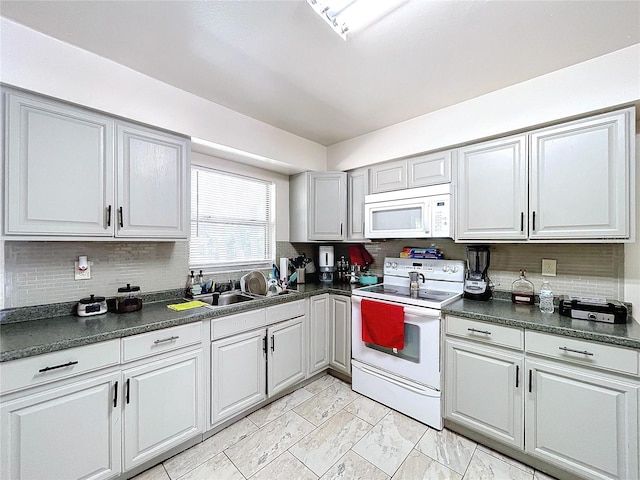 kitchen with dark countertops, white appliances, a sink, and marble finish floor