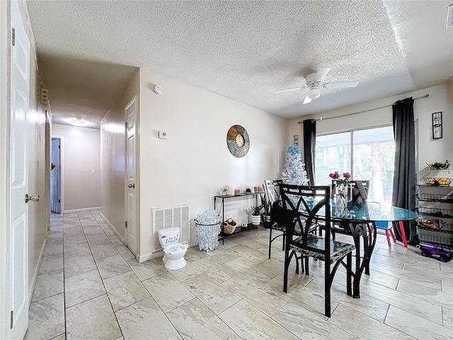 dining area with visible vents, ceiling fan, a textured ceiling, and baseboards