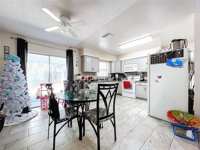 dining space featuring marble finish floor, visible vents, ceiling fan, and a textured ceiling