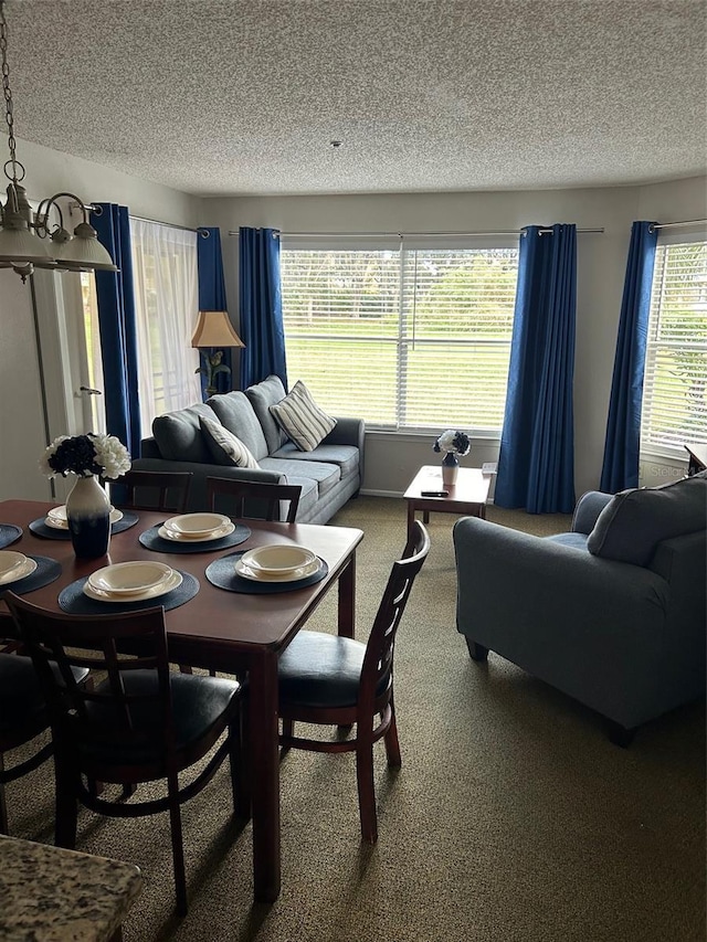 carpeted dining room featuring a textured ceiling