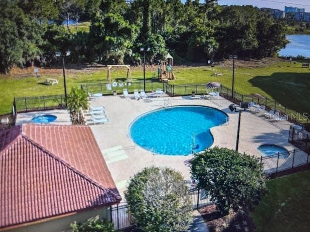 view of pool featuring a yard, a patio, and a community hot tub