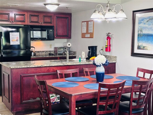 6337 Parc Corniche Dr Unit 2101, Orlando, FL 32821 - kitchen featuring black appliances, a chandelier, a sink, light stone countertops, and dark brown cabinets