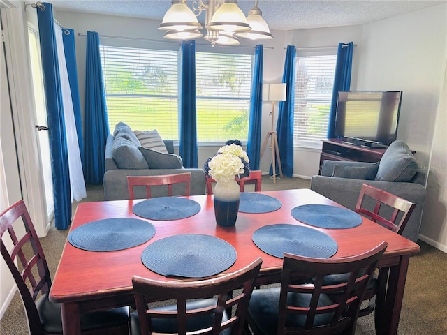6337 Parc Corniche Dr Unit 2101, Orlando, FL 32821 - carpeted dining room featuring a chandelier, baseboards, and a textured ceiling