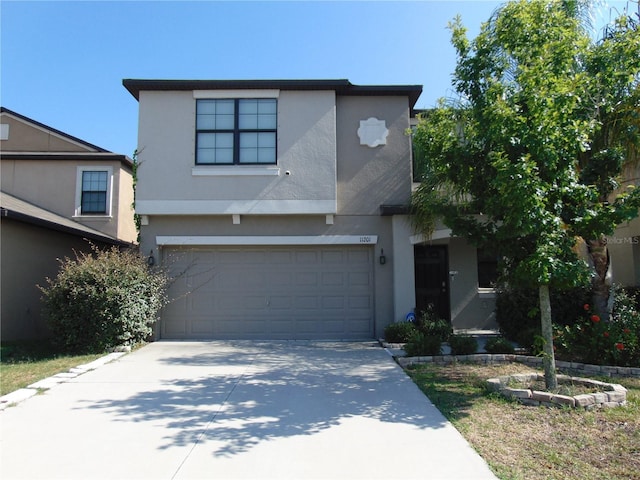 contemporary home featuring concrete driveway, an attached garage, and stucco siding