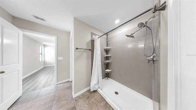 11201 Hudson Hills Ln, Riverview, FL 33579 - bathroom featuring tiled shower, baseboards, and tile patterned floors