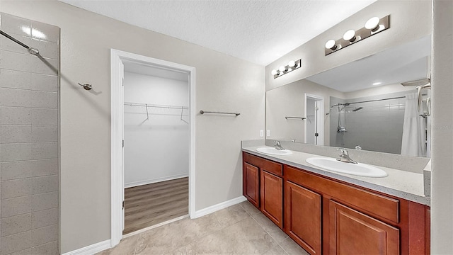 11201 Hudson Hills Ln, Riverview, FL 33579 - full bath featuring a tile shower, a spacious closet, tile patterned flooring, double vanity, and baseboards