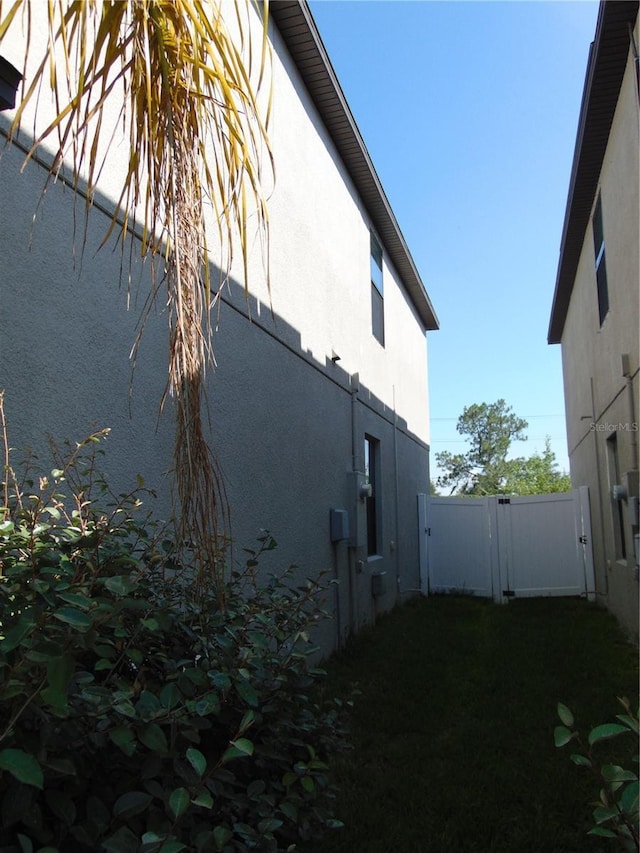 11201 Hudson Hills Ln, Riverview, FL 33579 - view of side of home featuring stucco siding, fence, and a gate