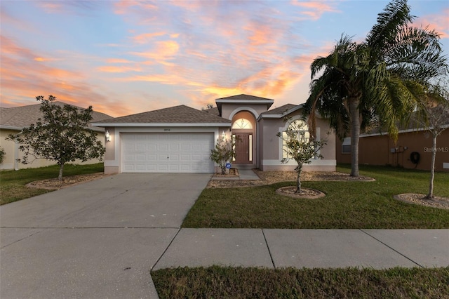 ranch-style house featuring driveway, a yard, an attached garage, and stucco siding