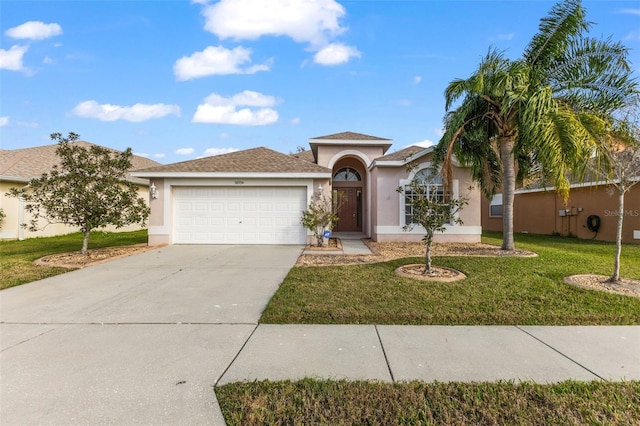 ranch-style home featuring an attached garage, driveway, a front yard, and stucco siding