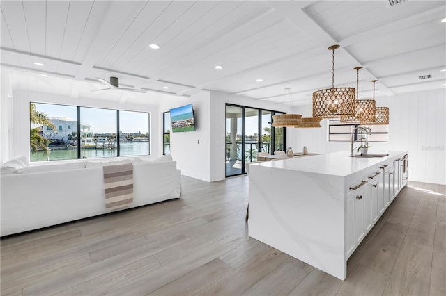 8505 Blind Pass Dr, Treasure Island, FL 33706 - kitchen featuring open floor plan, a sink, light wood-type flooring, light countertops, and a chandelier