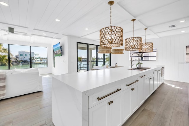 8505 Blind Pass Dr, Treasure Island, FL 33706 - kitchen featuring open floor plan, a chandelier, a sink, light wood finished floors, and recessed lighting
