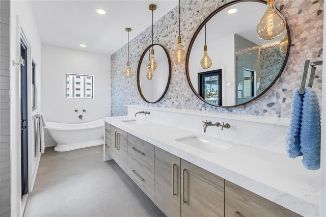 8505 Blind Pass Dr, Treasure Island, FL 33706 - full bath with wallpapered walls, a freestanding bath, double vanity, and recessed lighting