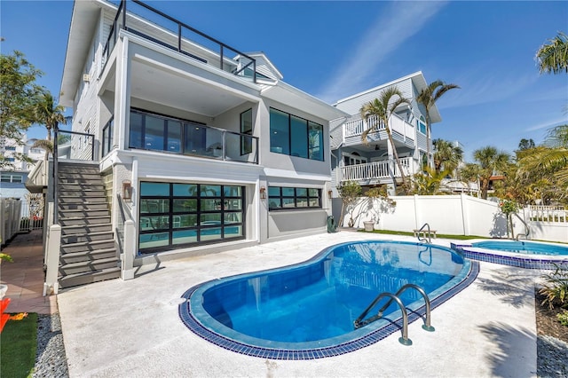 8505 Blind Pass Dr, Treasure Island, FL 33706 - rear view of house with stairway, fence, a patio, a pool with connected hot tub, and stucco siding