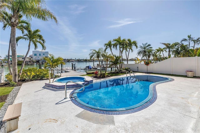 8505 Blind Pass Dr, Treasure Island, FL 33706 - view of pool with a water view, fence, a pool with connected hot tub, and a patio