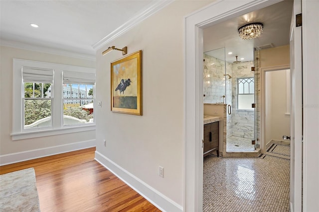 corridor featuring a healthy amount of sunlight, baseboards, and crown molding