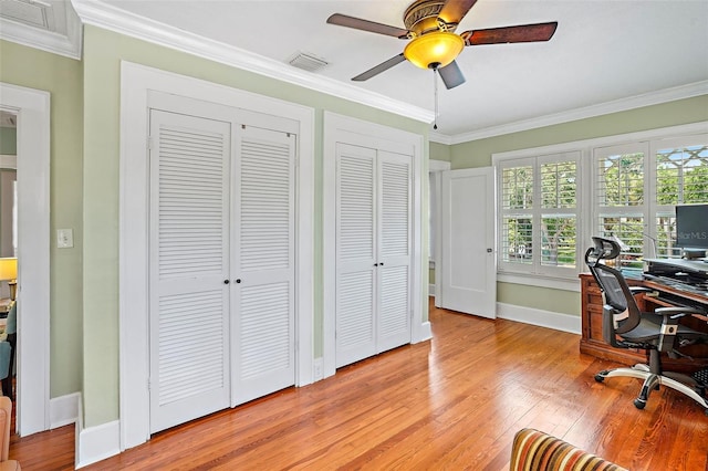 home office featuring light wood-type flooring, visible vents, and crown molding