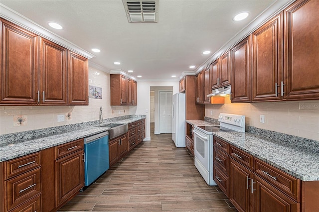 kitchen with sink, white appliances, hardwood / wood-style flooring, and light stone countertops