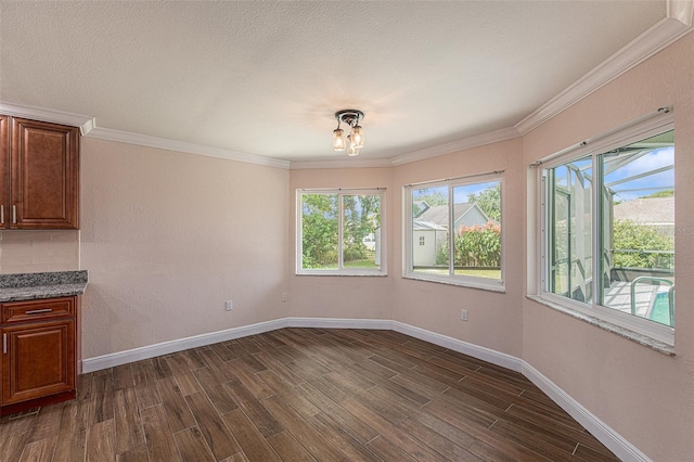 unfurnished dining area with dark hardwood / wood-style flooring, crown molding, and a textured ceiling