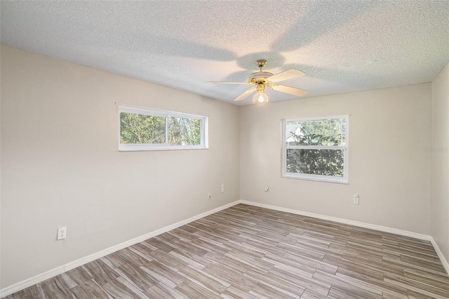 spare room featuring ceiling fan, plenty of natural light, and light wood-type flooring