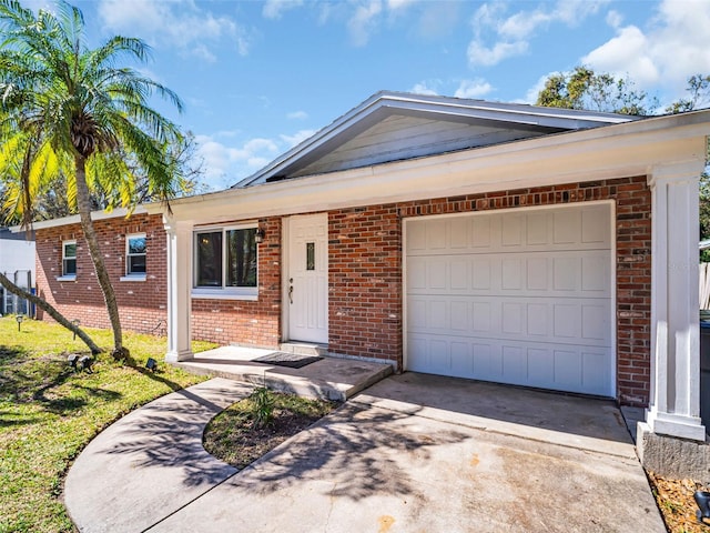 single story home featuring a garage, concrete driveway, and brick siding