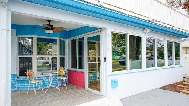 doorway to property with ceiling fan and a deck