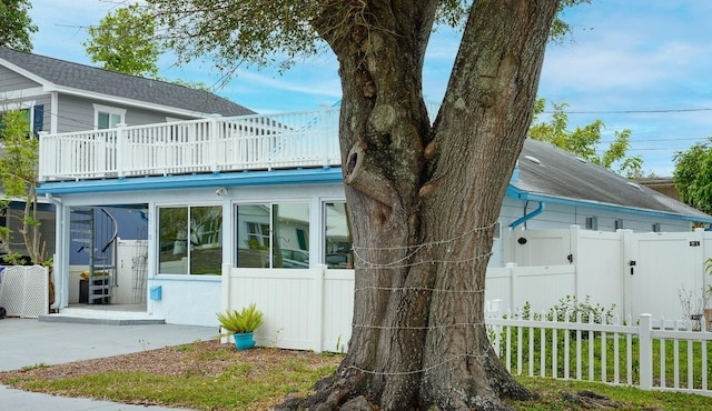 view of property exterior featuring fence and a balcony