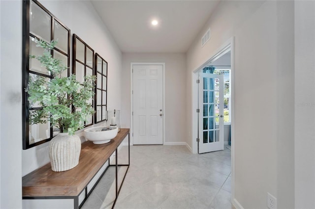 doorway to outside with baseboards and visible vents