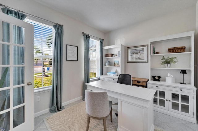 home office featuring light tile patterned flooring, a wealth of natural light, and baseboards