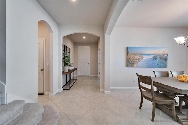 dining room with arched walkways, baseboards, and recessed lighting