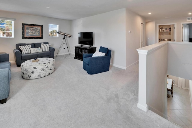 living area with recessed lighting, visible vents, a barn door, light carpet, and light tile patterned flooring