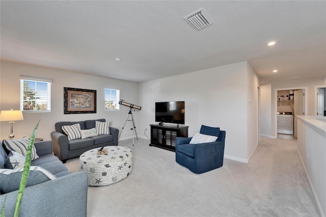 living room with washer / dryer, recessed lighting, visible vents, and light carpet