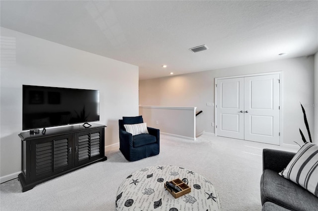 living room with a textured ceiling, recessed lighting, carpet flooring, visible vents, and baseboards