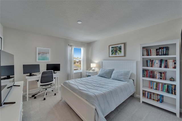 bedroom with light carpet, a textured ceiling, and baseboards