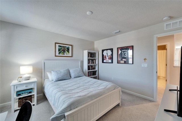 bedroom featuring light carpet, baseboards, visible vents, and a textured ceiling