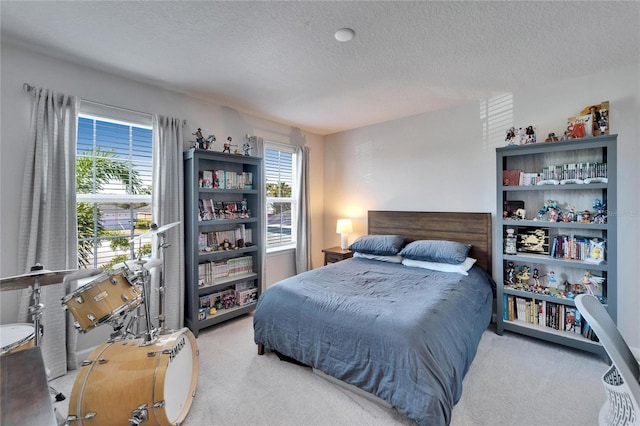 bedroom featuring light colored carpet and a textured ceiling