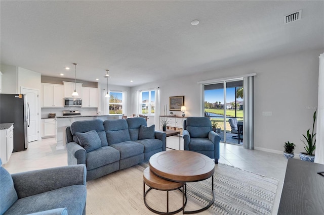 living area featuring visible vents, light tile patterned flooring, a wealth of natural light, and recessed lighting