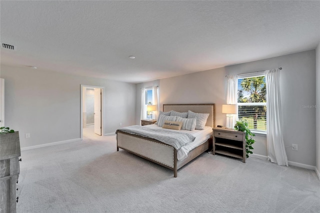 bedroom featuring baseboards, visible vents, and light colored carpet