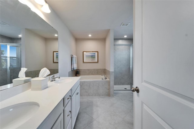 bathroom with a stall shower, visible vents, a sink, and a garden tub