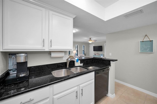 kitchen featuring dishwasher, dark stone counters, light tile patterned flooring, sink, and white cabinetry