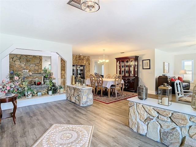 interior space with a notable chandelier and wood finished floors