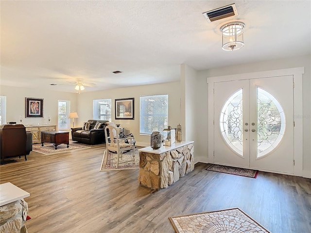 foyer entrance with french doors, light wood-type flooring, and visible vents